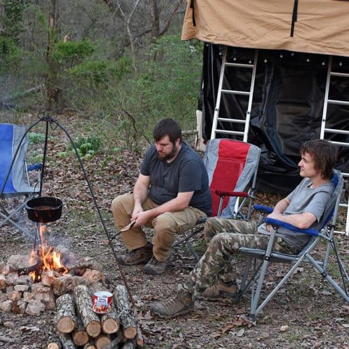 dad and son enjoying campfire cooking and rooftop tent camping