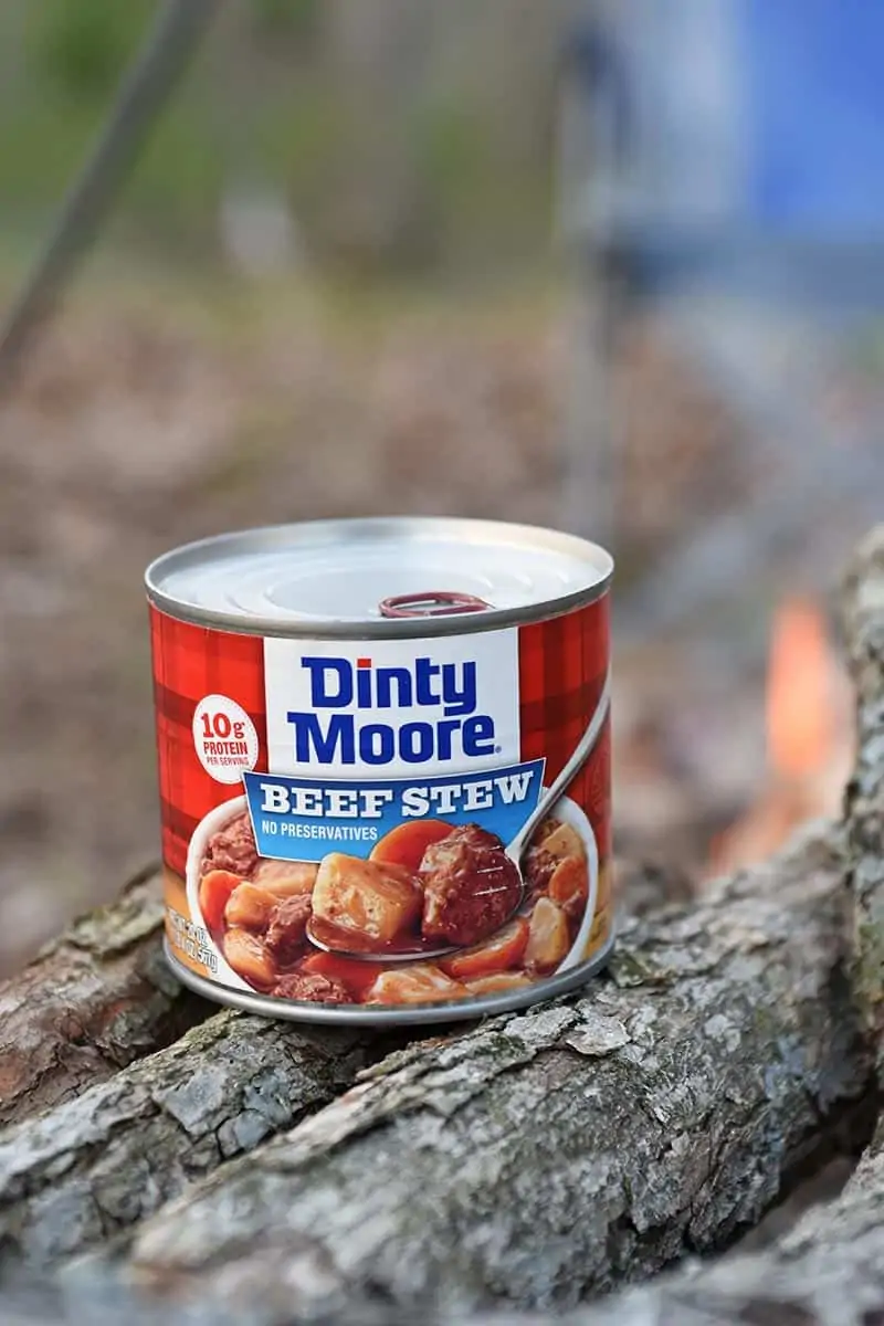 can of DINTY MOORE® Beef Stew with campfire in background