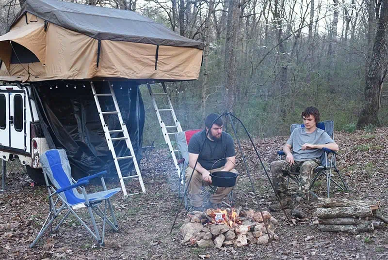 father and son enjoying campfire cooking 
