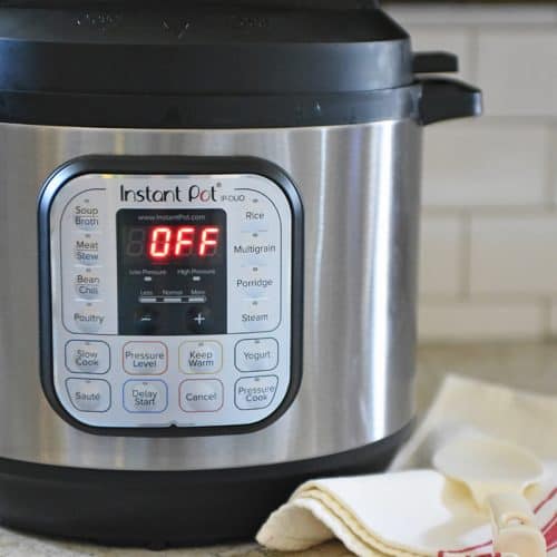 Instant Pot sitting on kitchen counter with towel and spoon