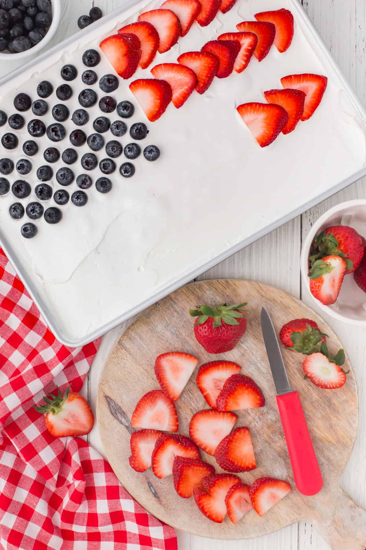 4th of July poke cake in a 9x13 baking pan with fresh fruit on top