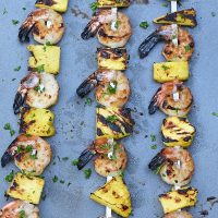 maple bourbon grilled shrimp kabobs with pineapple on a cookie sheet