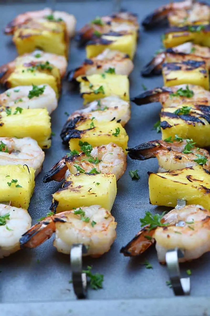 up close shrimp kabobs with pineapple grilled and placed on a cookie sheet