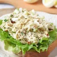 open-faced chicken salad recipe with eggs sandwich with lettuce on white plate