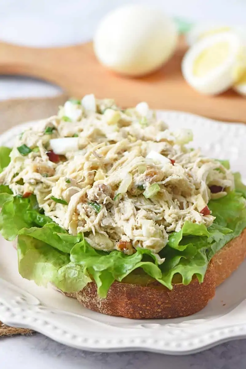 open-faced chicken salad sandwich  with lettuce on white plate