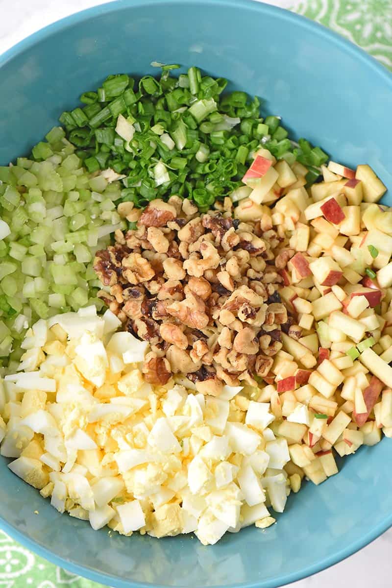 ingredients for easy chicken salad recipe with eggs, including celery, green onions, apple, hard boiled eggs, and walnuts