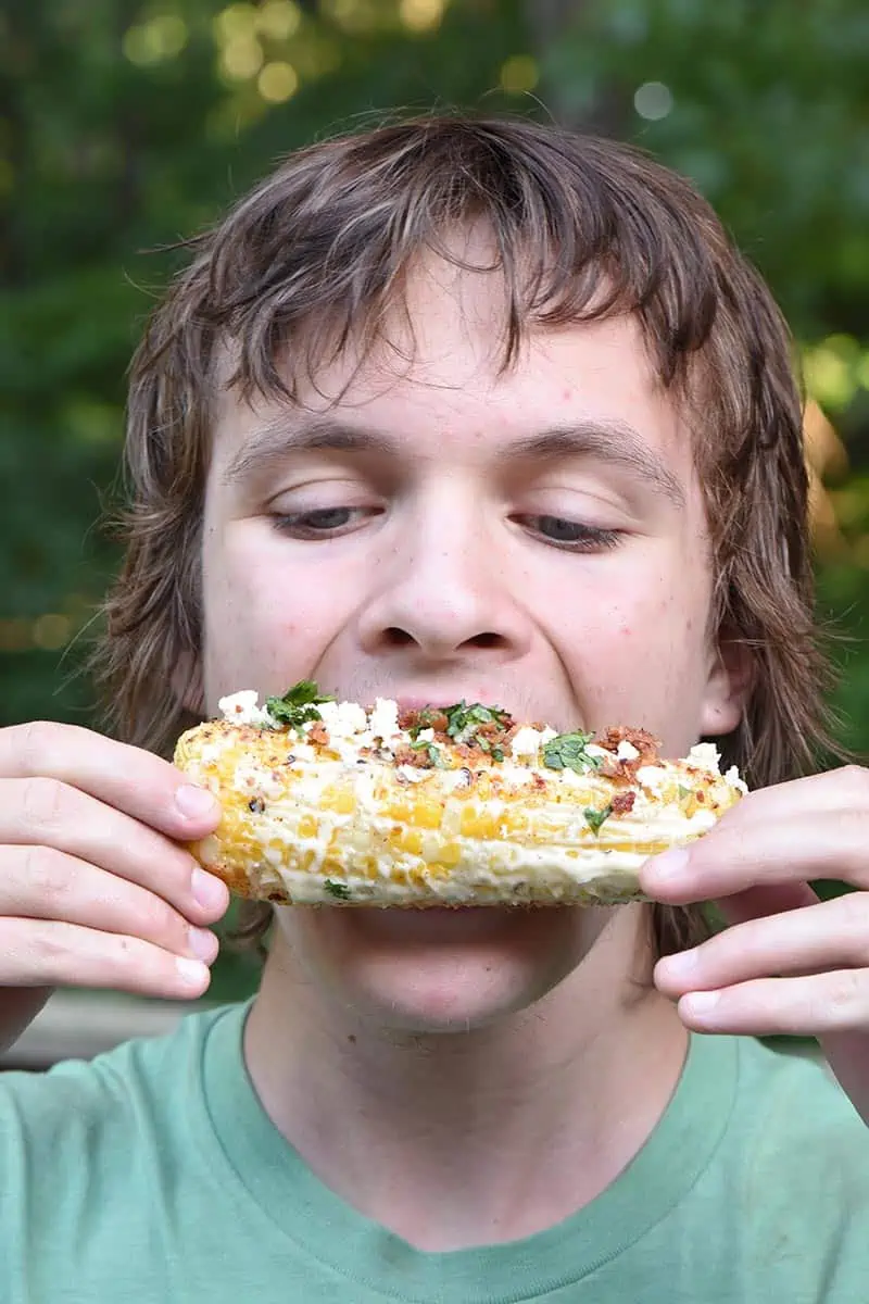 boy eating Mexican corn