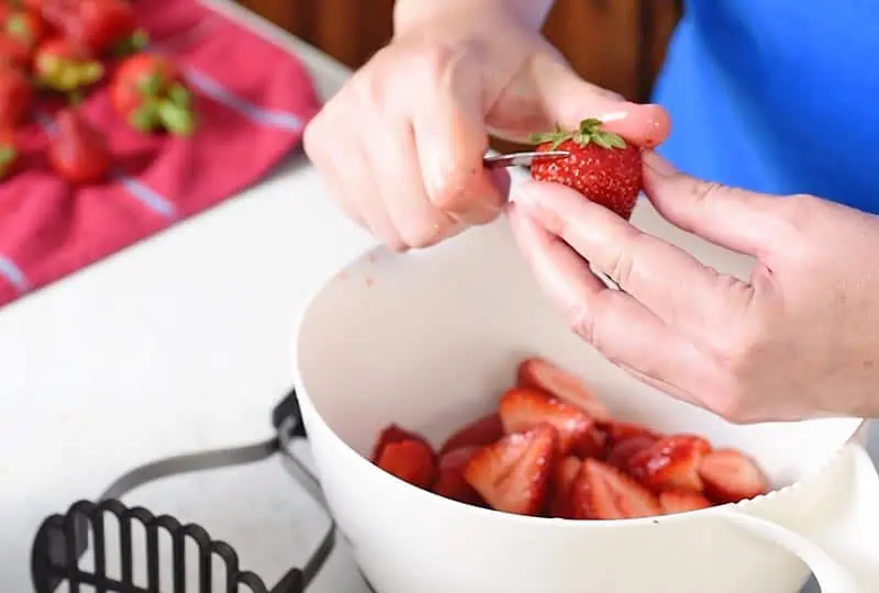 stemming strawberries with a paring knife for easy strawberry freezer jam