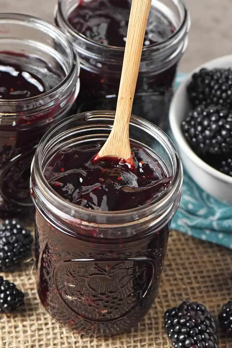blackberry jam without pectin in half pint jar with small wooden spoon