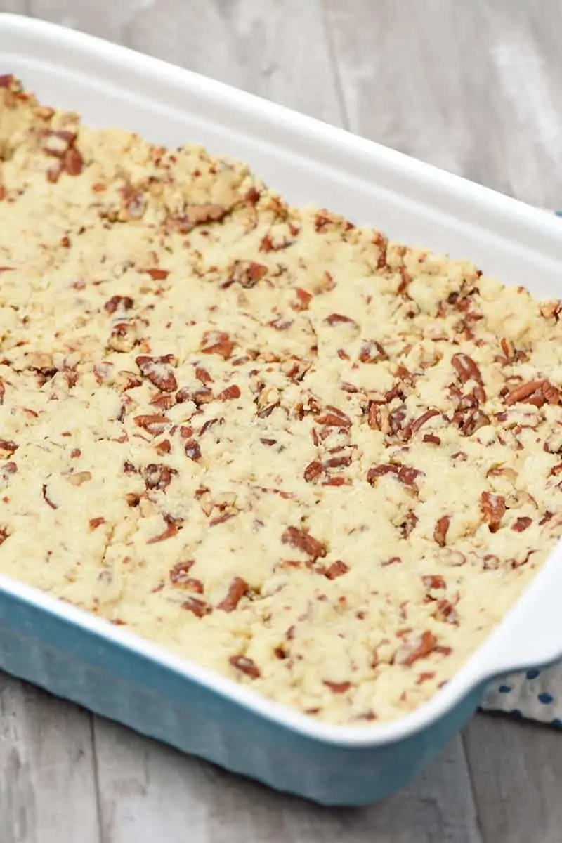pressed in nutty pie crust, made with butter, flour, and pecans in blue baking dish