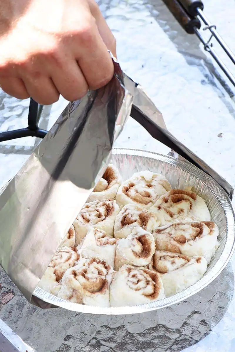 aluminum foil sling to lower camp cinnamon rolls into Dutch oven for cooking