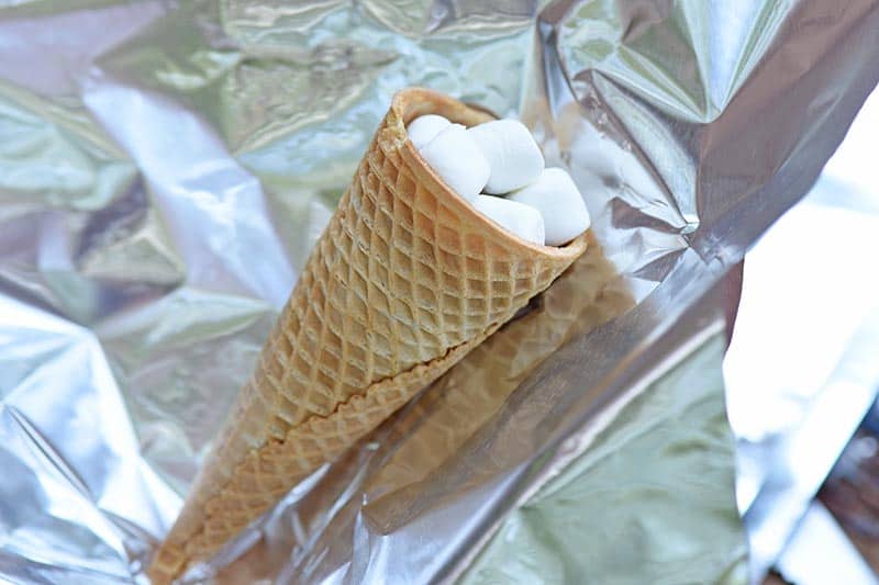 wrapping campfire cones s'mores in aluminum foil for grilling