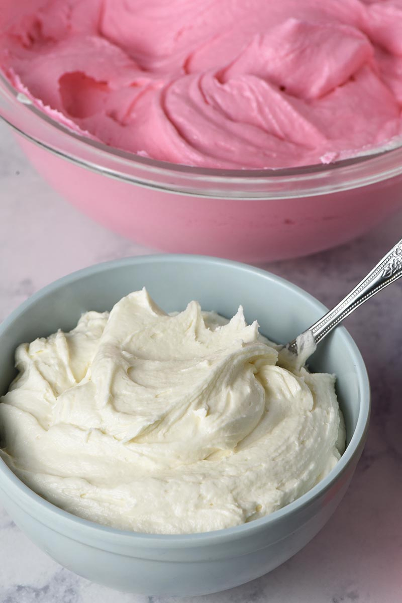 the best buttercream frosting colored pink and white in separate bowls