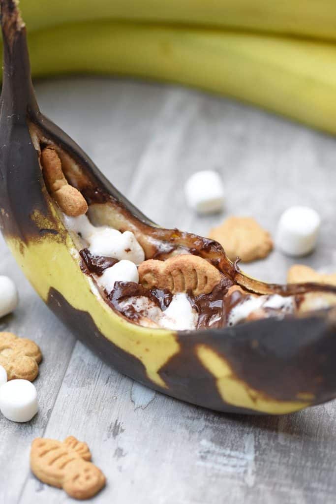ooey gooey banana s'mores close up with chocolate chips, mini marshmallows, and graham crackers