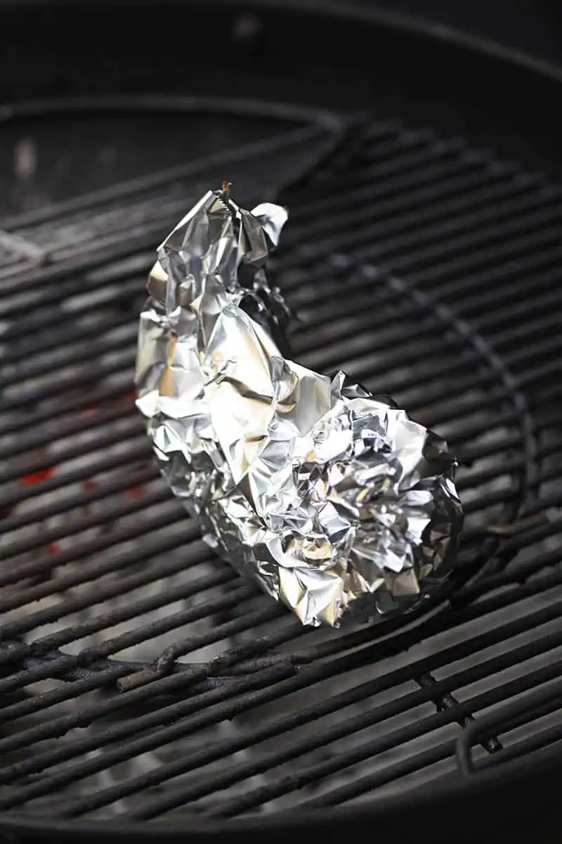 banana boats wrapped in aluminum foil, cooking on the grill