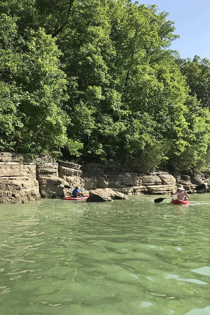 paddling kayak through boulders sticking up out of Beaver Lake
