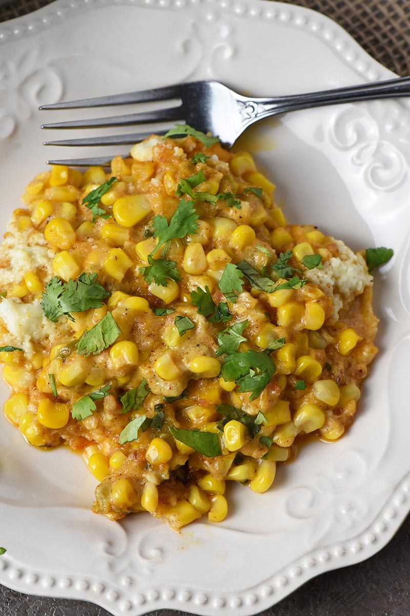 Mexican corn casserole dished out on white Pioneer Woman plate