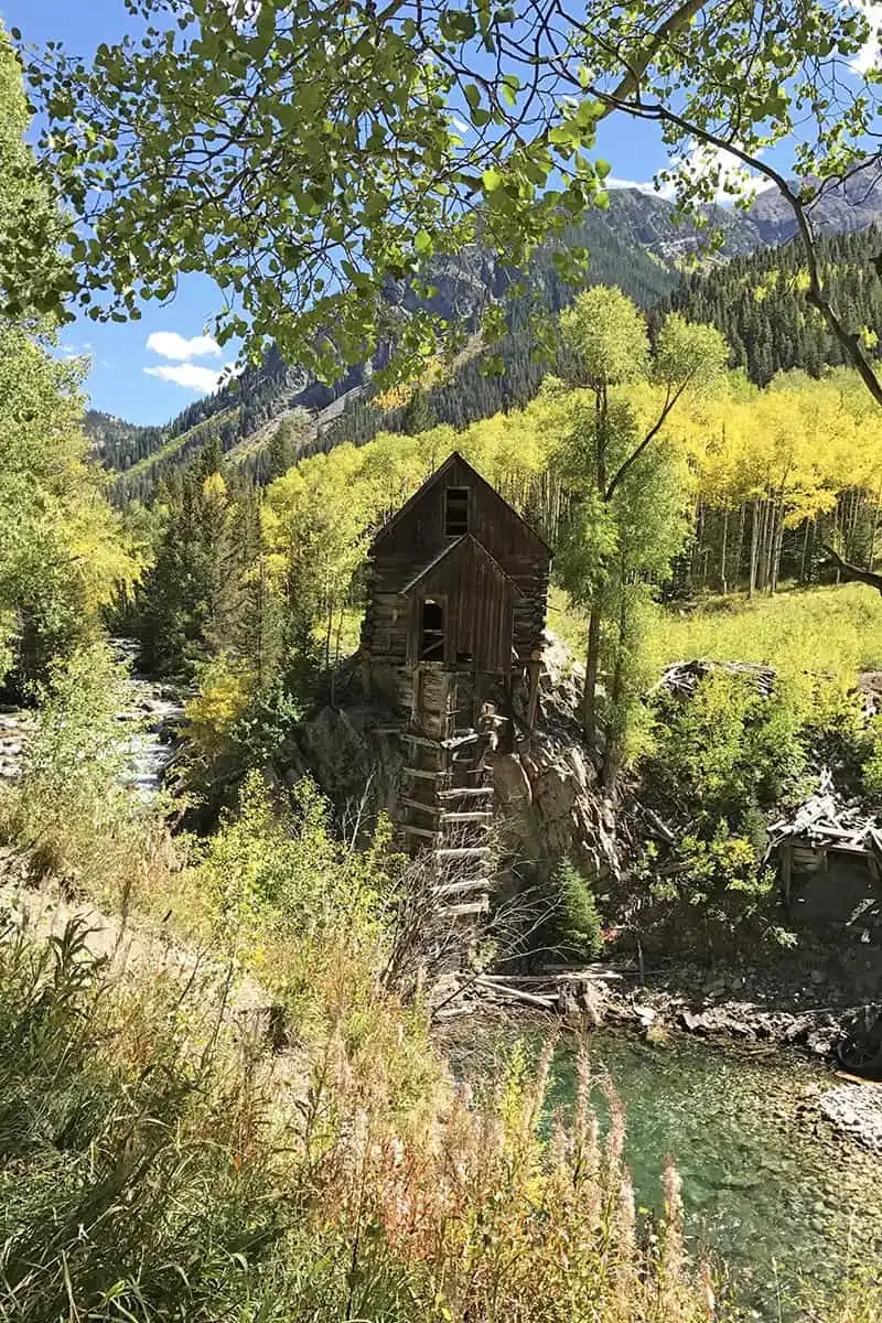 ghostly Crystal Mill in Colorado surrounded by golden yellow aspen trees and mountains