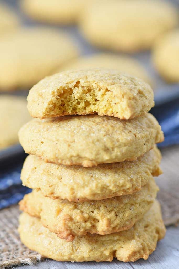 stack of soft pumpkin spice sugar cookies, made from scratch, on wood countertop with burlap cloth