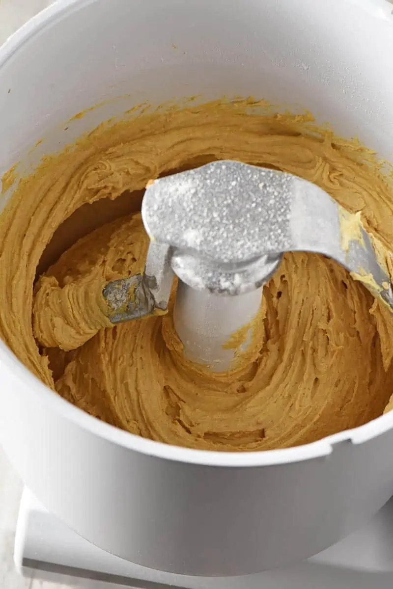 mixing up recipe for pumpkin spice cookies in mixer, cookie dough