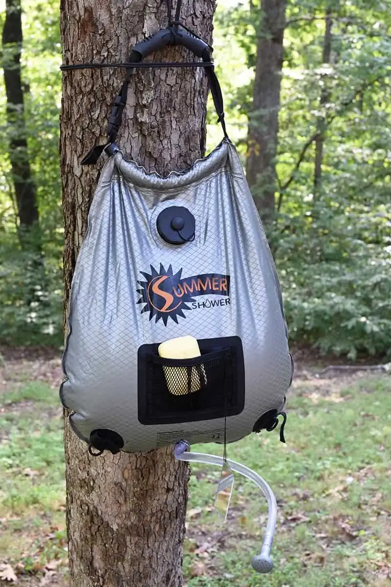 hang outdoor camp shower bag on tree, somewhere where you won't hurt any vegetation, where you'll ultimately leave no trace