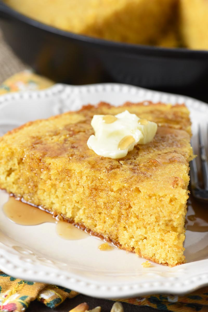 buttermilk cornbread with butter and maple syrup on white Pioneer Woman plate