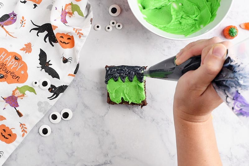 adding black icing for hair to Halloween Frankenstein brownies, Wilton black food color