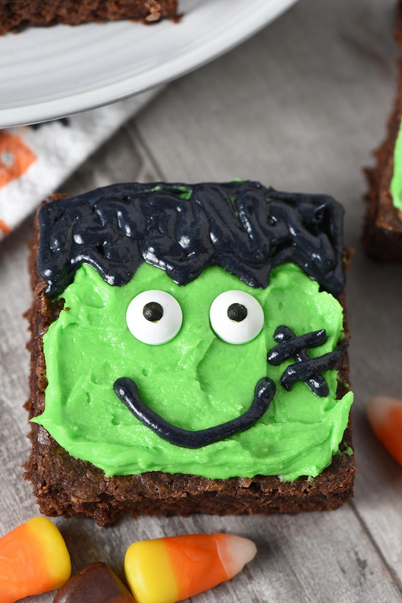 close up Frankenstein Halloween brownies on wood countertop with candy corn