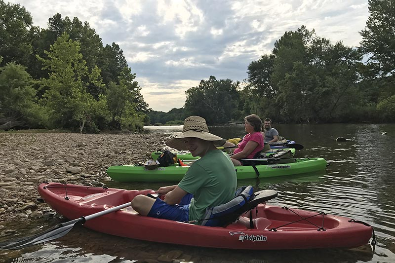 family resting on the banks of the Jacks Fork River in Missouri