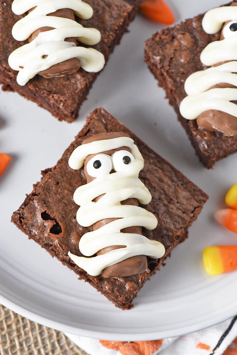 mummy halloween brownies made with Fun Size Twix bars on a plate with candy corn