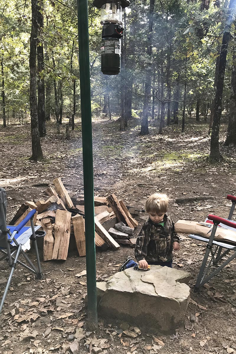 toddler playing with trucks in Petit Jean State Park campsite
