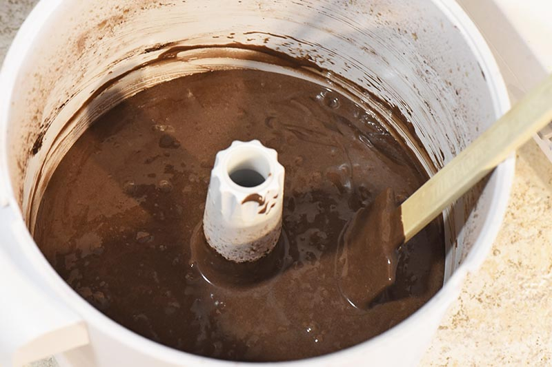 batter for chocolate cupcakes in white mixing bowl with spatula