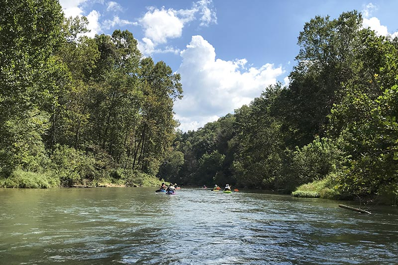 kayaking over ripples on the Current River in Ozark National Scenic Riverways