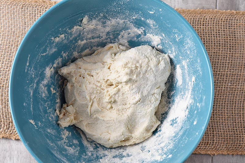 mixing dough for drop biscuits in blue mixing bowl