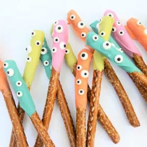 Halloween dipped pretzels with candy eyeballs on white countertop
