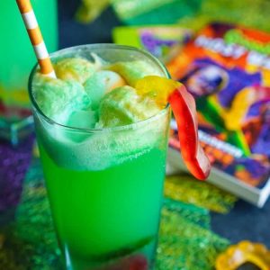 green Goosebumps Halloween punch in glass with paper straw and gummy worms