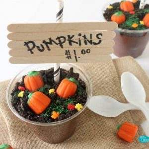 pumpkin patch pudding cups on burlap cloth with candy pumpkins and plastic spoons