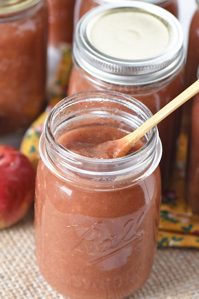 easy Instant Pot cinnamon applesauce in Ball canning jar with wooden spoon