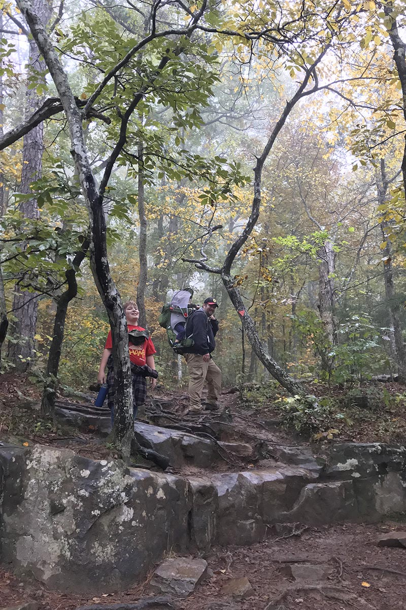 Arkansas hikers following Hawksbill Crag Trail through an autumn forest