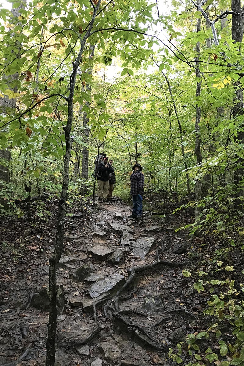 family hiking muddy Whitaker Point Trail in Arkansas