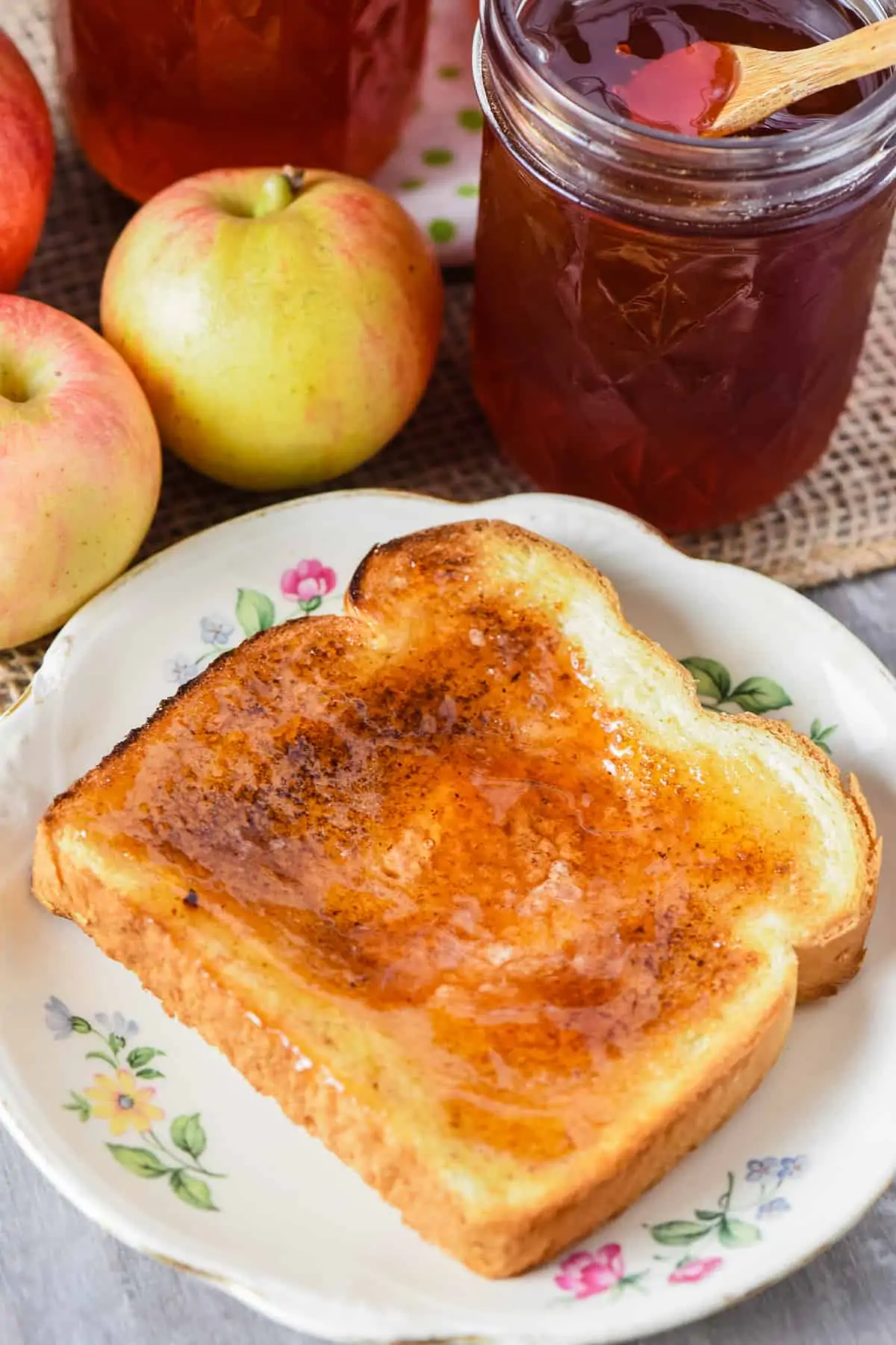 homemade apple jelly on toast on white flowered plate