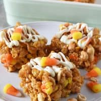 peanut butter Corn Flake bars drizzled with white chocolate and candy corn on gray plate