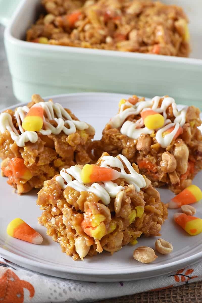 peanut butter Corn Flake bars drizzled with white chocolate and candy corn on gray plate