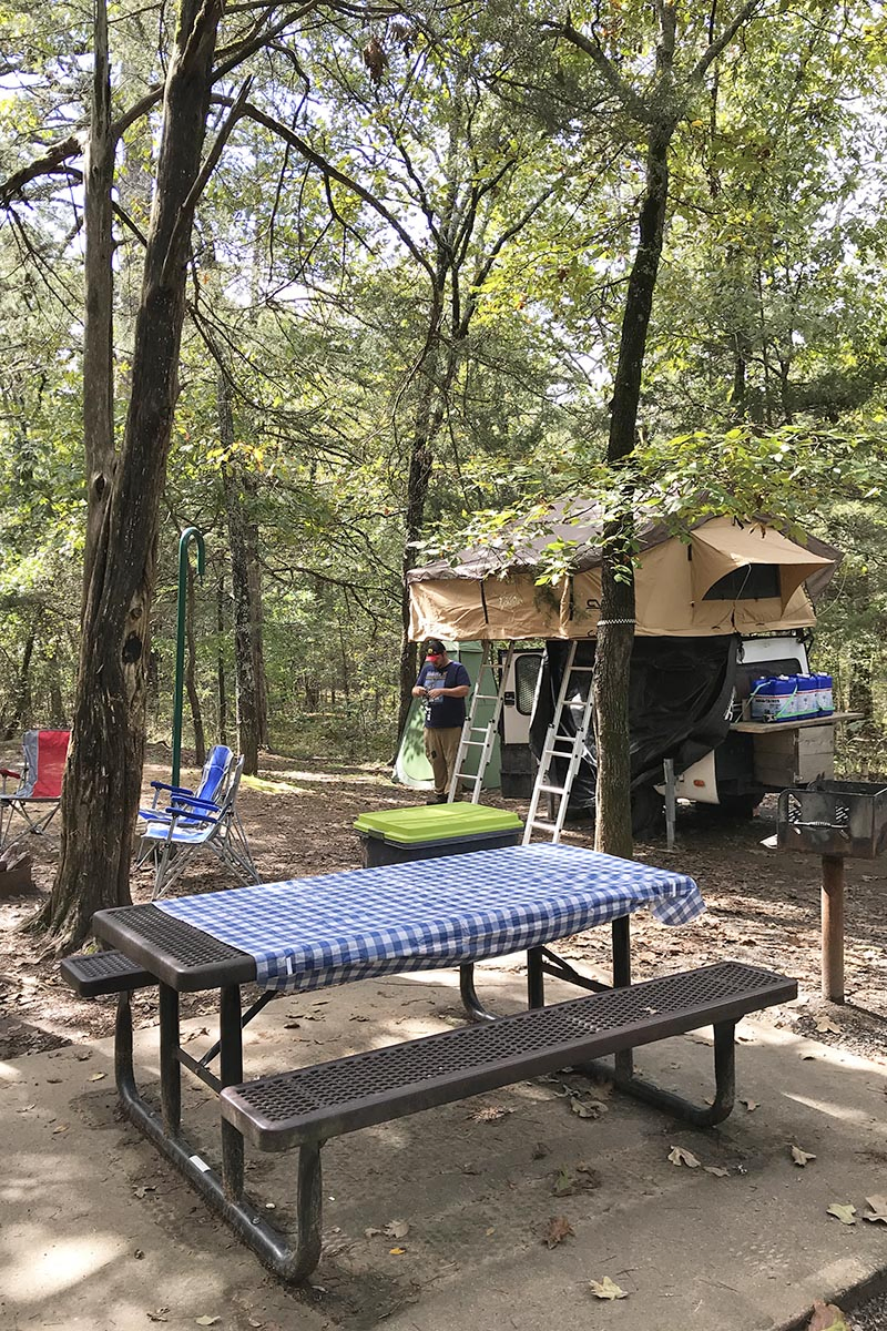 rooftop tent setup in Petit Jean State Park campground with picnic table and camping chairs