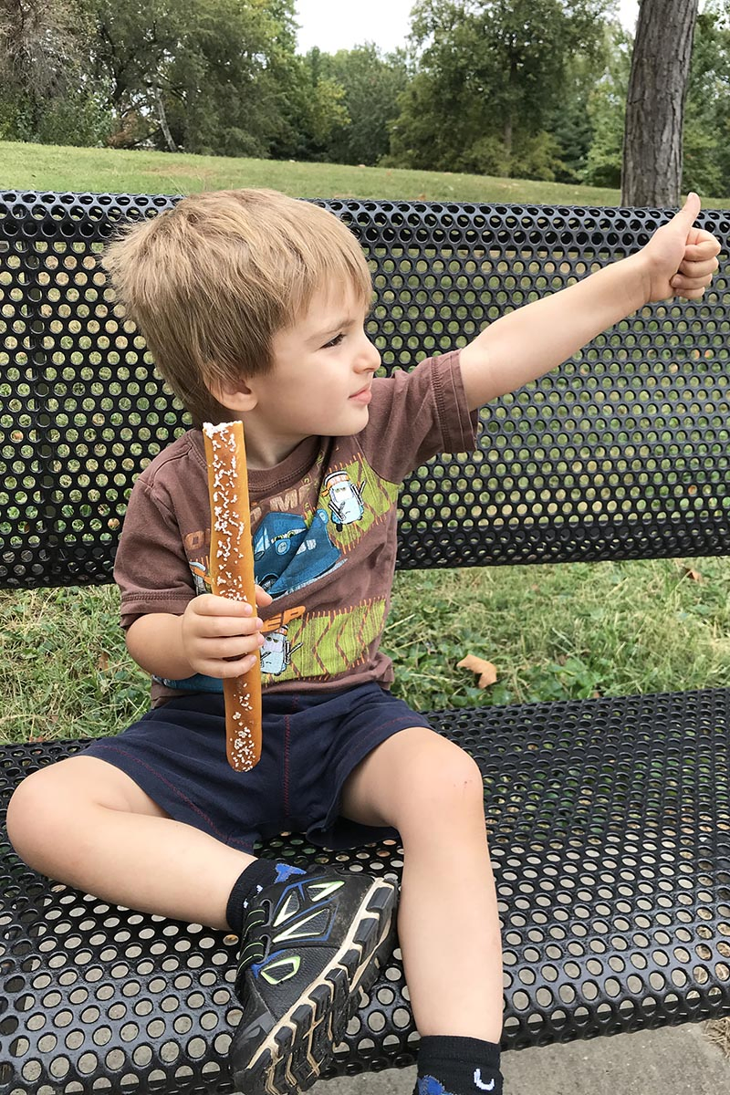 toddler eating pretzel stick from Gus' Pretzel, one of many delicious St. Louis foods