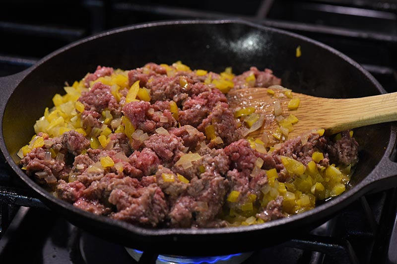 ground beef mixture for taco sloppy joes cooking in cast iron skillet on stovetop