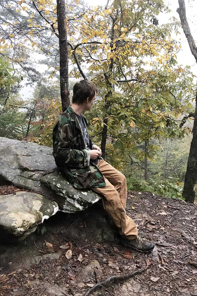 teen hiking Hawksbill Crag, taking in the view of the Ozark National Forest and Upper Buffalo River Wilderness