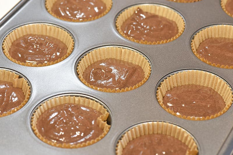 not yet baked chocolate cupcakes in brown paper cupcake liners in muffin pan