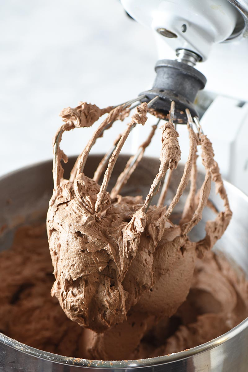 mixing up milk chocolate buttercream frosting with KitchenAid mixing whisk