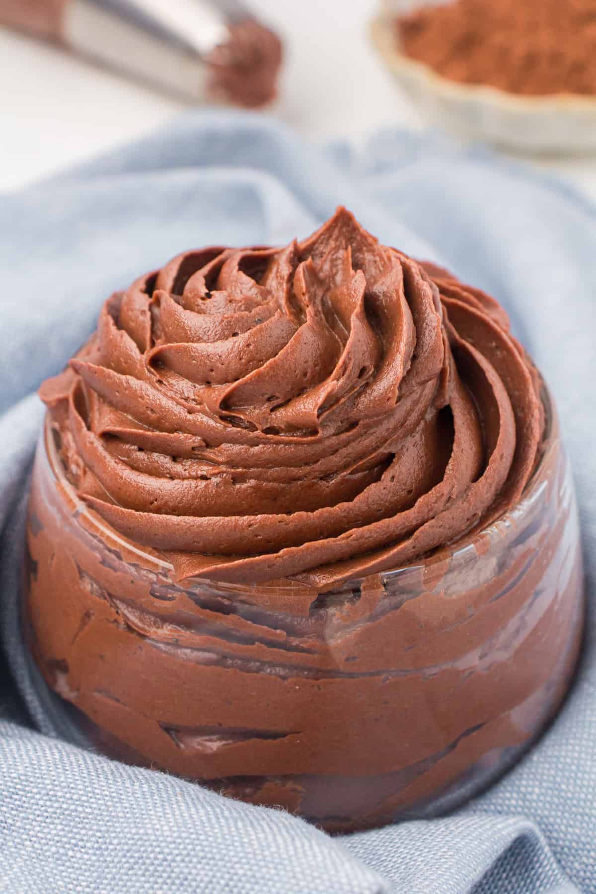 chocolate buttercream frosting piped into a small glass bowl